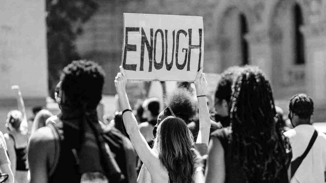 person holding a sign at a protest reading, 